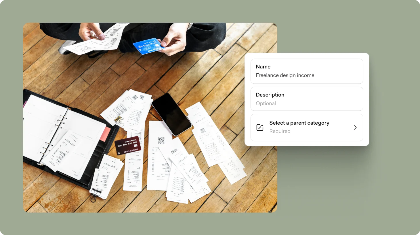 Hands sort paper receipts and a card on a wooden floor, beside an app panel for categorising a transaction named 'Freelance design income'