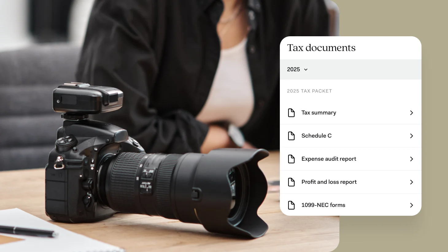 A person in a dark blazer sits at a desk with a professional DSLR camera, while a tax documents interface displays on screen showing 2025 tax packet options including tax summary, Schedule C, expense audit report, profit and loss report, and 1099-NEC forms