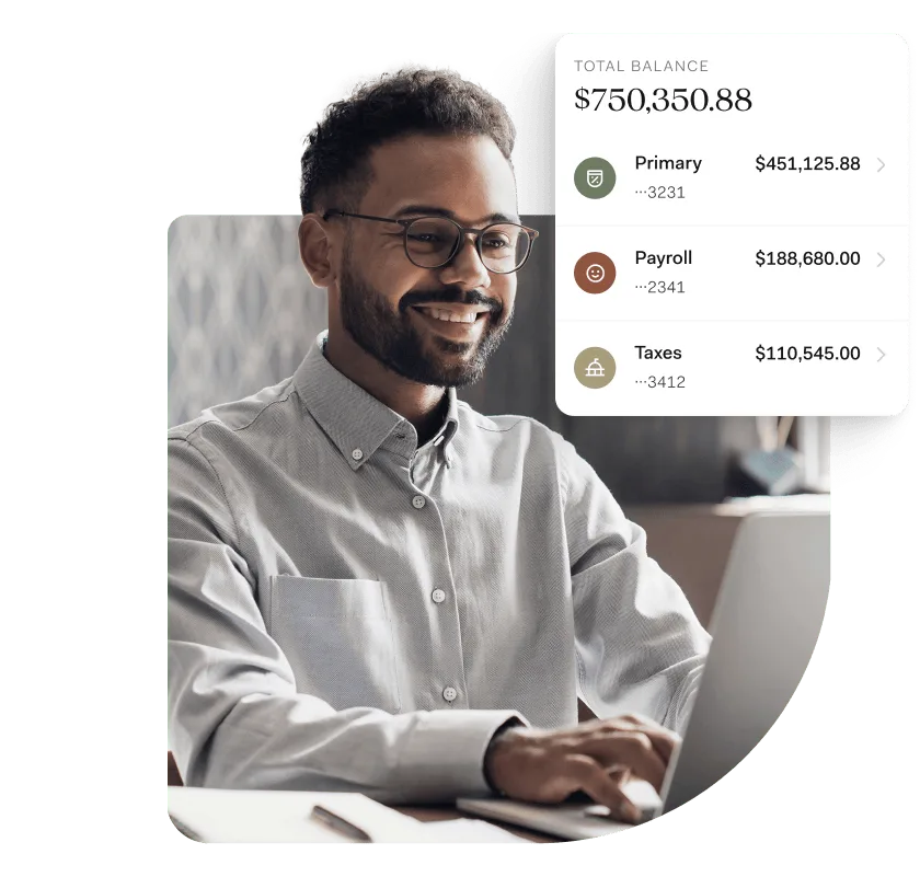 A smiling man with glasses types on a laptop in a home office setting. Overlaid on the image is a digital banking dashboard showing a total balance of $750,350.88, split across three labeled pockets: Primary ($451,125.88), Payroll ($188,680.00), and Taxes ($110,545.00). The interface highlights Found’s organized approach to managing business finances.