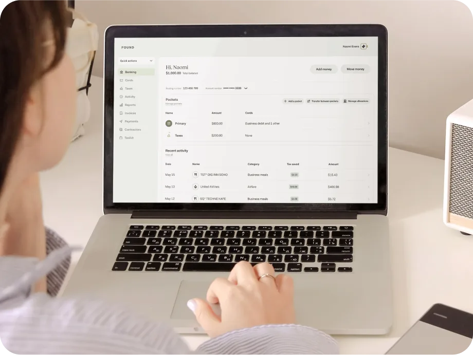 A business owner at a desk working in the Found banking dashboard on a laptop